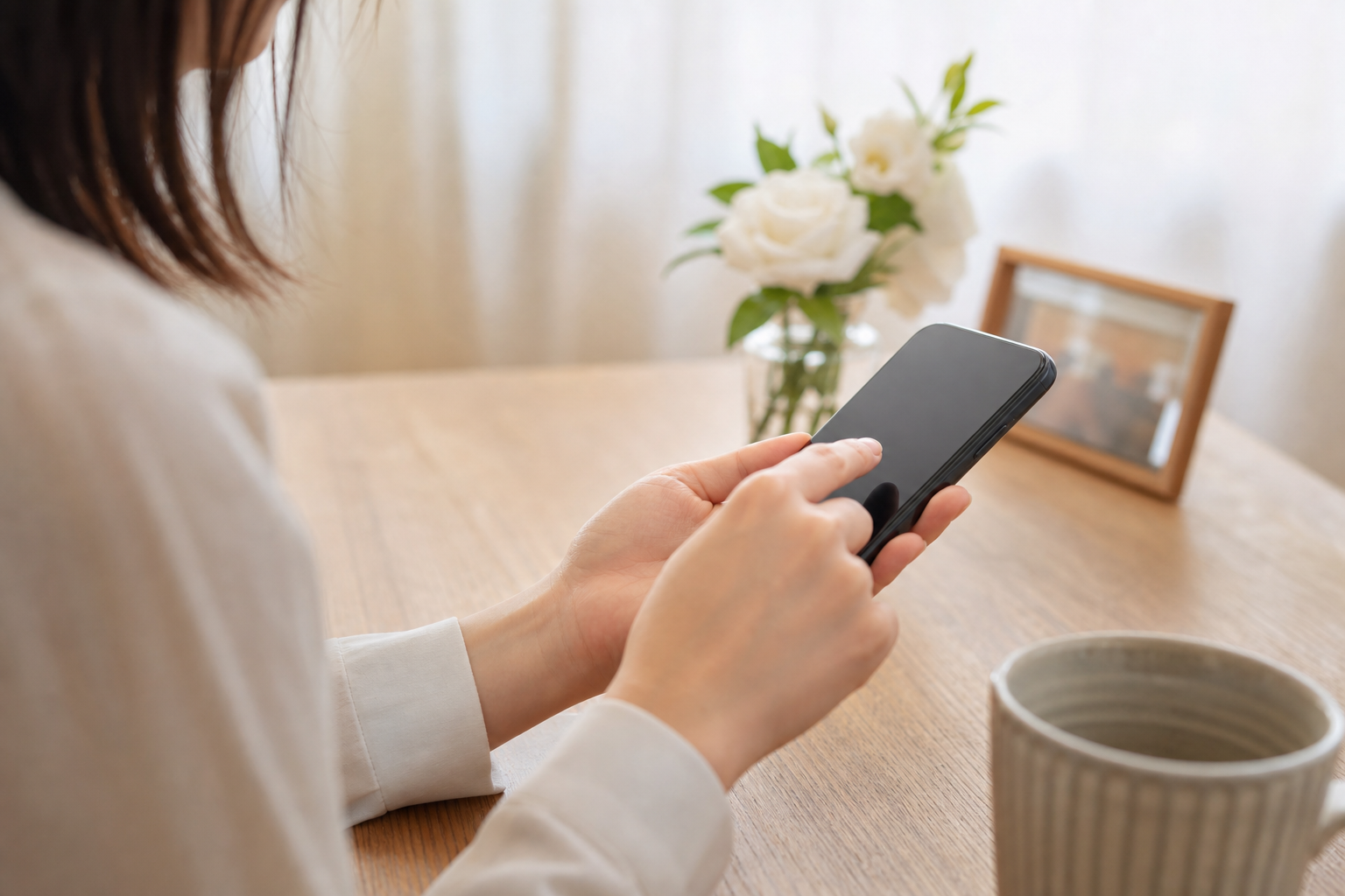 スマートフォンでお悔やみメッセージを打つ女性の手元