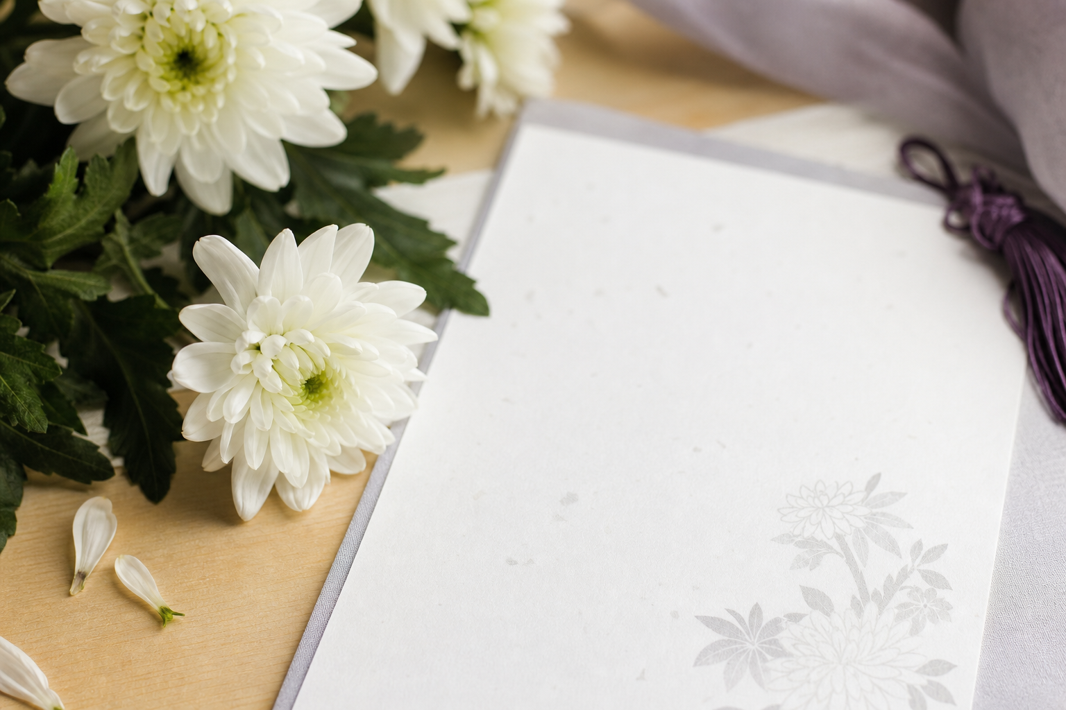 白い菊の花と薄墨で書かれた挨拶状の便箋