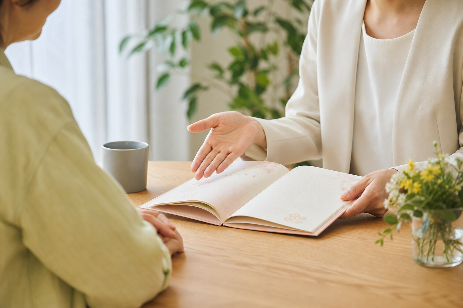 エンディングノートを開いて説明する女性カウンセラーの手元